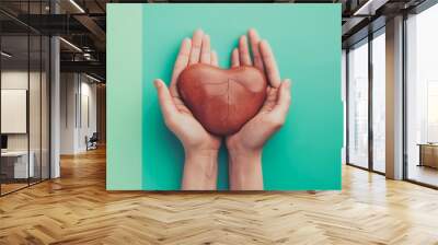 Human liver between two women's palms on a blue and green background. Healthy liver concept. Wall mural