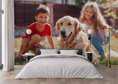 On the backyard lawn, two kids are having fun with their handsome golden retriever dog. They pet, play, tackle and scratch. Happy dog has a toy football in his jaws. Suburb house in summer. Wall mural