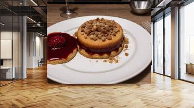 A dessert served on a long plate with raspberry sauce and crumbs. Wall mural