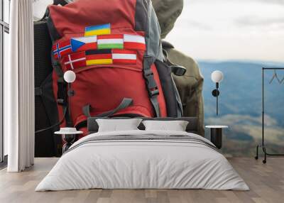 travel and hiking life style photography concept picture of different European countries flag stripes on backpack in mountains route environment with blurred background copy space for your text here  Wall mural