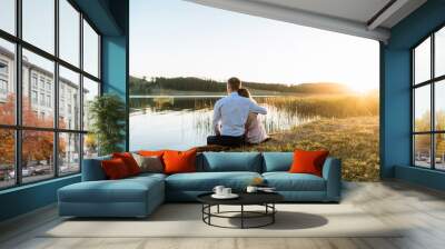 a young couple in love, a guy and a girl on an outdoor date on a lake at sunset in a nature park. the concept of romantic relationships, love Wall mural