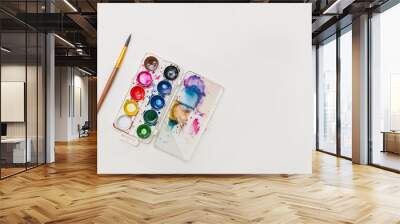 colored watercolor paints with a palette and a brush for drawing on a white background copy the space. concept of hobbies and creativity Wall mural