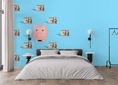 . Pattern of American dollar banknotes and pink piggy bank on bright blue background. The concept of financial savings and miscellaneous transactions. Wall mural