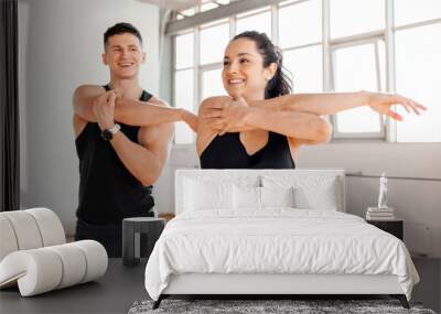 athletic couple in sportswear warm up in the gym in the morning, fitness girl and coach man go in for sports in training Wall mural