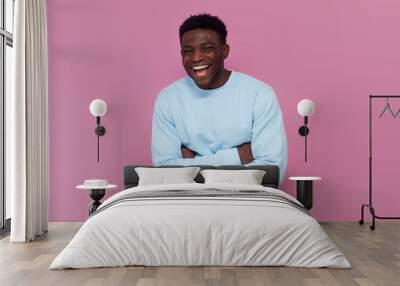 cheerful african american man in blue sweater laughing on pink isolated background Wall mural