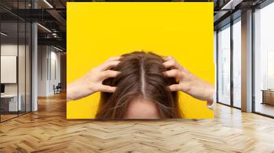 girl scratches her hair and head with her hands for dandruff and skin problems, close-up of the head Wall mural