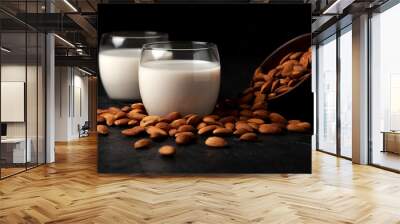 glass of almond milk without lactose and sugar with sprinkled nuts, a veggie milk drink on a black table Wall mural