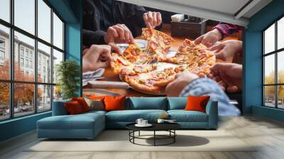 group of students friends eat Italian pizza, hands take slices of pizza in a restaurant Wall mural