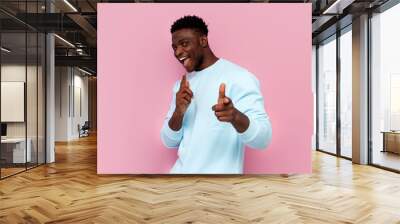 I choose you. african american man in blue sweater points with his hands at the camera on pink isolated background Wall mural