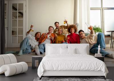 multiracial group of young people at house party eating pizza and drinking beer and having fun with friends Wall mural