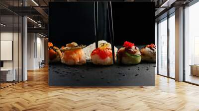 Hand holding chopsticks a elegant piece of sushi at restaurant. California Roll Sushi Japanese food Rice ball. Front view. Creative Japanese cuisine concept. High quality photo Wall mural