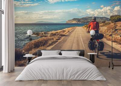 a male cyclist rides near the sea Wall mural