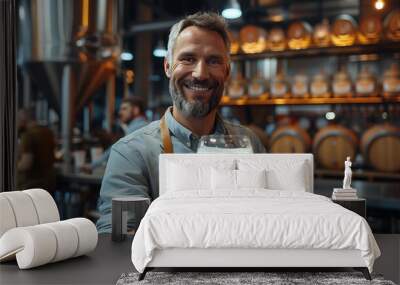 Portrait of smiling brewer with glass of beer at the manufacturing Wall mural