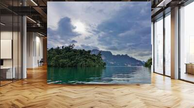 The surface of the lake is smooth and shiny. The shores are lush with tropical vegetation. A rocky island is visible in the distance. Reflection in the water, Thailand. Cheow Lan Lake Wall mural