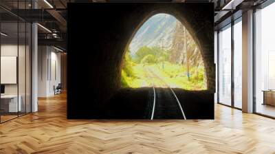 Bright sunny escape from dark old stone mountain tunnel on the Circum-Baikal railway. Background of a summer landscape for travel in Siberia. Conceptual background of there is always a way out. Wall mural