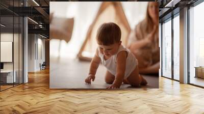 Small child under one year old plays in the room with mom against the backdrop of wigwam in beige shades. The infant baby is happy and dressed  bodysuit. The cozy home environment Wall mural