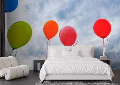 Blue, light green, orange, pink, red, purple balloons on blue sky background Wall mural