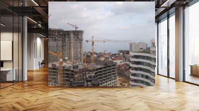 Construction site of a high-rise residential building on the seashore. Tower cranes Wall mural