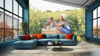 little girl in a rapeseed field with a puppy cavalier king charles spaniel Wall mural