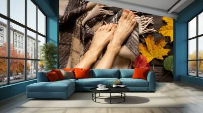 female legs in autumn yellow leaves on a brown plaid on a wooden floor, feet on a wooden floor, home comfort and relaxation, legs autumn Wall mural