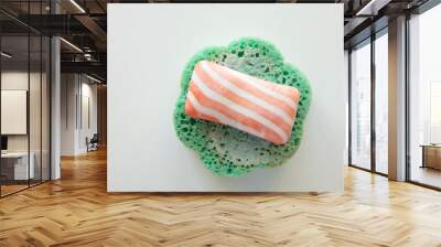 striped soap lies on a wet green sponge on a white background in a bathroom Wall mural