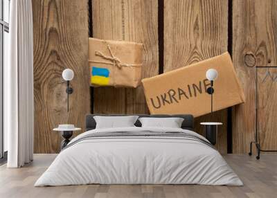 Two boxes with the text Ukraine and the flag of Ukraine on a wooden table, humanitarian cargo for Ukraine, war, help people affected by the war Wall mural