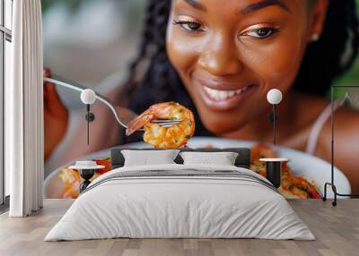 Delightful cuisine: black woman smiles, eating boiled shrimp Wall mural