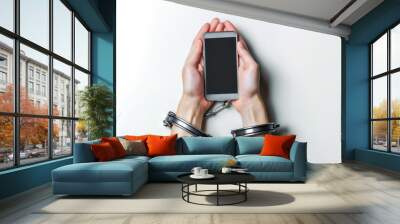 Men's hands are handcuffed to a smartphone on a white background, a concept of unhealthy gadget addiction Wall mural