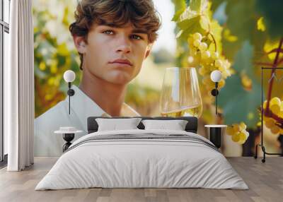 Young handsome man tasting white wine in vineyard Wall mural