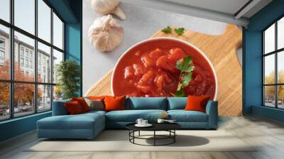 Canned whole peeled tomatoes with juice and parsley on table Wall mural