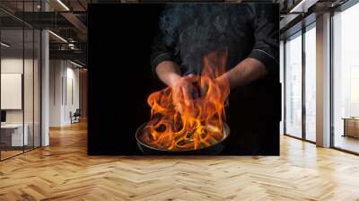 Chef or cook cooking food in pan with fire flame on black background. Restaurant and hotel service concept. Free advertising space Wall mural