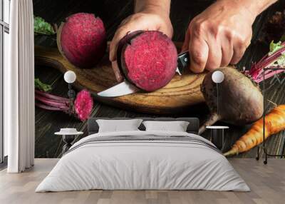 Hands of a cook with a knife cut beetroot to prepare delicious borscht. Ukrainian national cuisine. Copy space Wall mural