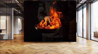 Professional chef cooking food in pan with fire flame on black background. Restaurant and hotel service concept. Asian cuisine Wall mural