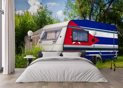 A car trailer, a motor home, painted in the national flag of  Cuba stands parked in a mountainous. The concept of road transport, trade, export and import between countries. Wall mural