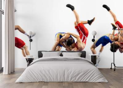 A set of high wrestling throws, tricks. Two young male athletes in blue and red wrestling tights wrestling on a white background Wall mural