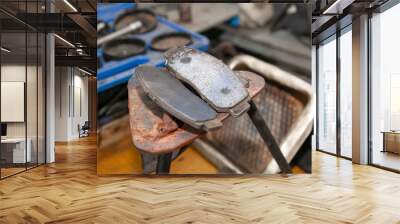 A set of two old automobile brake pads on a garage. Wall mural