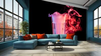 A  transparent  glass filled with a cloud from a red vape smokes and stands on a black isolated background Wall mural