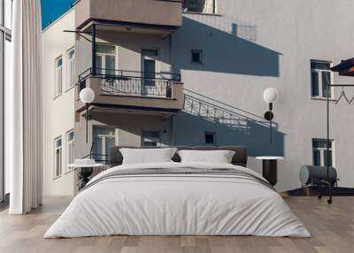 Close-up of a white stone house with balconies with forged metal railings Wall mural