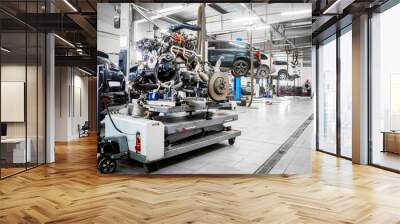 Engine, automatic transmission and chassis of the car on an electron-pneumatic trolley on the background of a workshop for car repair and tire fitting with cars raised on a lift. Car workshop concept Wall mural