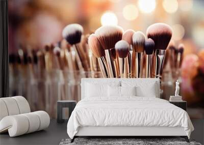 Various professional make - up brushes of a makeup artist in a transparent glass on a light blurred background. Wall mural