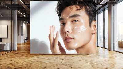 A Korean man applying vitamin C serum, boosting radiance and reducing pigmentation Wall mural