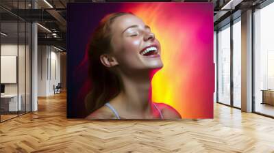 Beautiful young woman laughing and looking up. Portrait of smiling girl with closed eyes on colorful background Wall mural