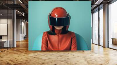 Futuristic portrait of a seated girl in an orange leather jacket with a futuristic VR retro helmet against a blue wall. Wall mural