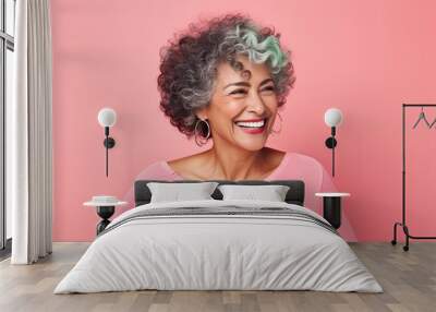 Portrait of a well-groomed smiling middle-aged Latino-American woman on a pink background. Wall mural