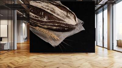 Rustic dark rye bread on black background. Freshly baked sourdough bread. Copy space. Wall mural