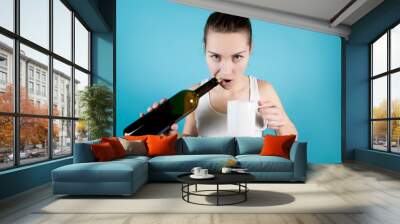 A young woman opens a bottle of wine with her teeth pulling out a cork Wall mural