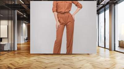 Attractive young blonde model with perfect slim body posing in trendy orange pantsuit full length. Beautiful fashion girl standing in stylish classic clothing isolated on white studio background Wall mural