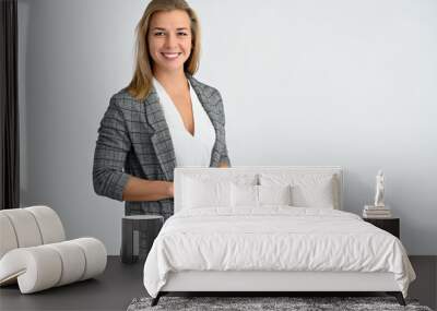 Close-up portrait of a cute caucasian blonde female student girl in a gray jacket on a white background. Wide smile, happiness. It is in different poses. Wall mural