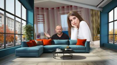 Family conflict, family problems, family relationships of a disgruntled father and adult daughter in a room on the sofa. Wall mural