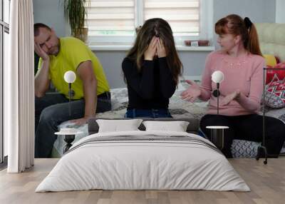 Photograph of the problems, the conflict of a disgruntled, swearing father, mother and brunette girl with long dark hair in the room. They are sitting on the sofa and are unhappy. Wall mural